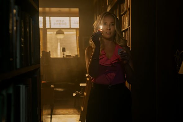 Anna Camp as Madeleine Lockwood holding a lit matchstick in You S5