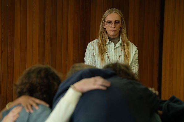 Toni Collette as Evelyn Wade standing in front of students hugging after a "Hot Seat" therapy session in episode 103 of 'Wayward'.