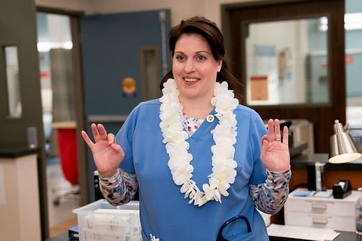 Allison Tolman as Alex with a Lei around her neck in "Aloha, Everyone"