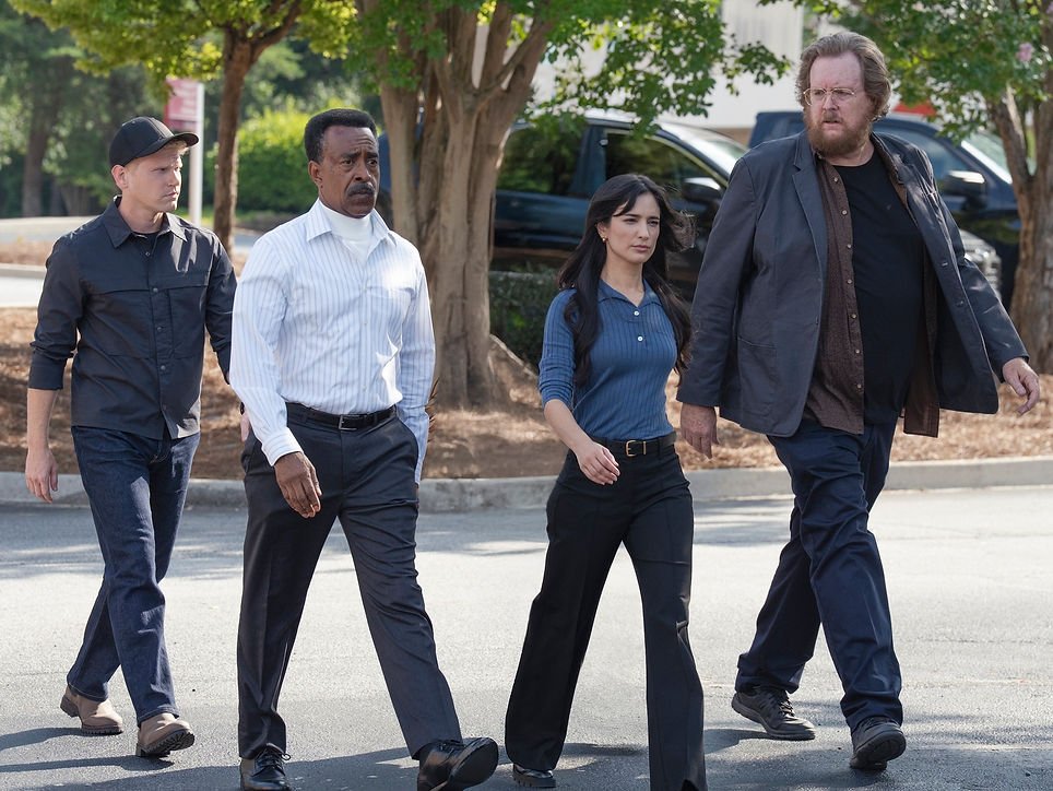 Brandon Stanley as Kline, Tim Meadows as Langston Fleury, Sol Rodriguez as Sasha Bordeaux and Steve Agee as Economos walking in a parking lot in Peacemaker Season 2