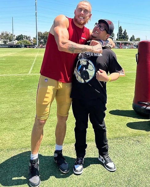 The author being put in a headlock by NFL player George Kittle