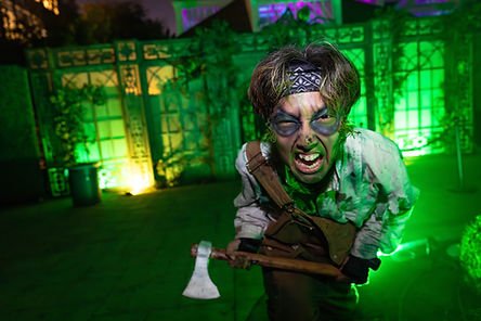 A cast member holding an axe and making a threatening face at the Winchester Mystery House