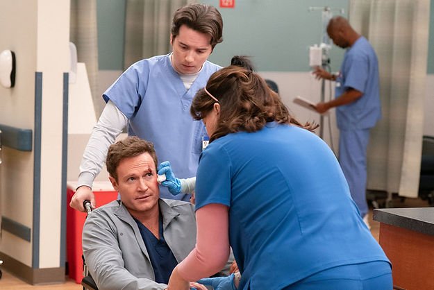 Mekki Leeper as Matt, holding onto wheelchair handles, Josh Lawson as Bruce, having a face wound attended to by Allison Tolman as Alex in "Mama Bear Activated."