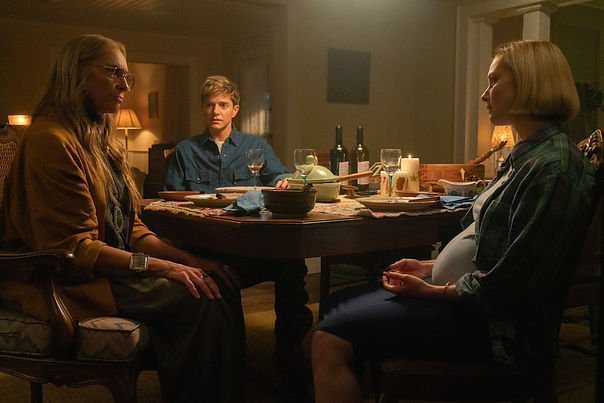 Toni Collette as Evelyn, Mae Martin as Alex Dempsey, and Sarah Gadon as Laura sat at a dinner table in episode 102 of 'Wayward'.