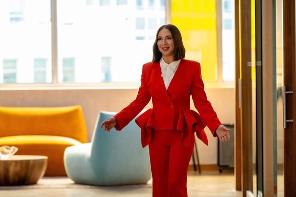 Maya Rudolph in a red suit and her arms out in 'Loot.'