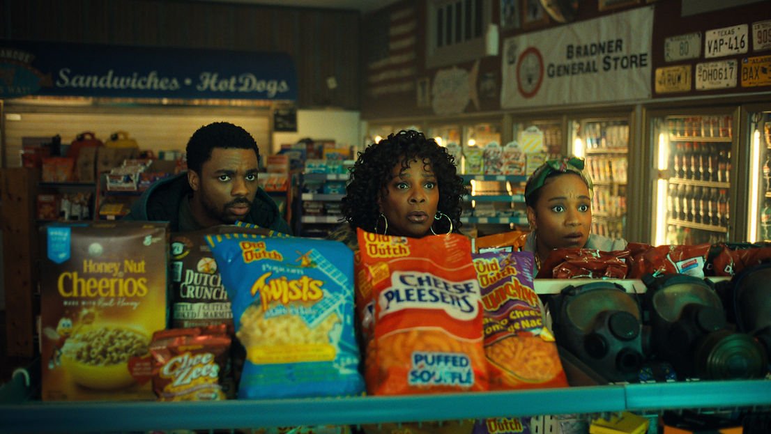 Vince Staples as Vince Staples, Vanessa Bell Calloway as Anita and Naté Jones as Bri hiding behind a shelf in The Vince Staples Show Season 2