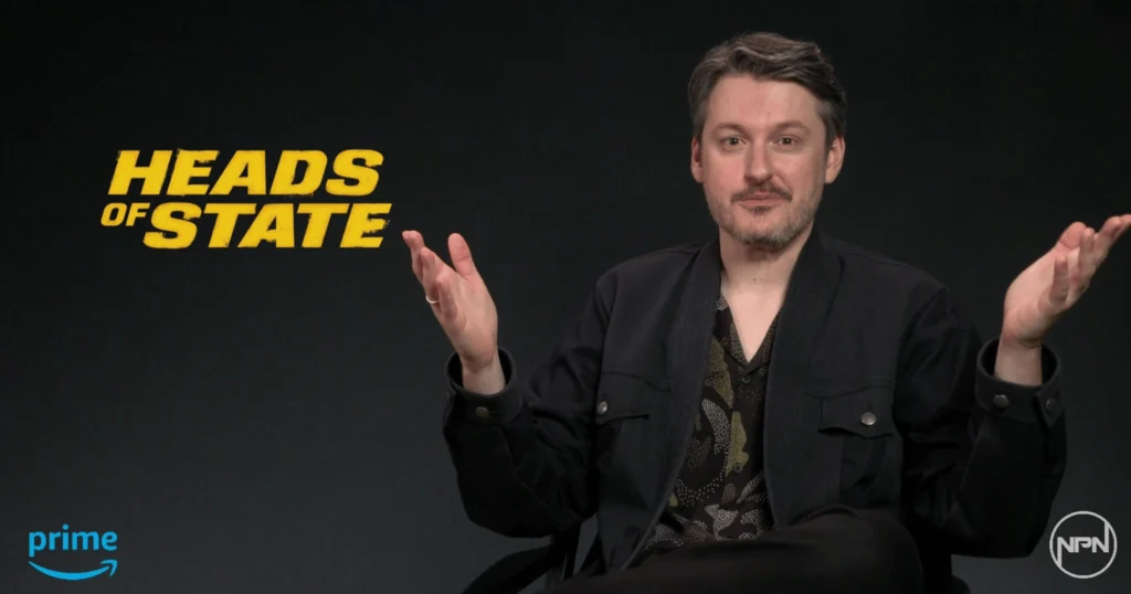 Ilya Naishuller in black with a black background and the yellow logo for Heads of State