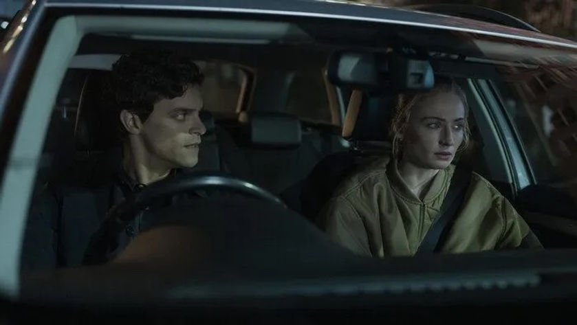 Jacob Fortune-Lloyd as DCI Rhys Covac and Sophie Turner as Zara Dunne sit in a car in 'Steal,' Season 1, Episode 1. 