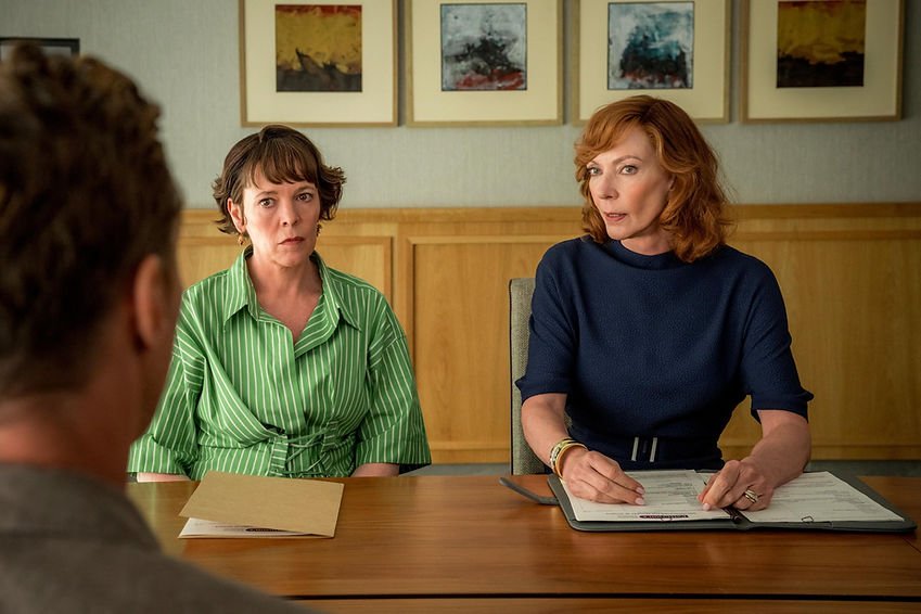 Olivia Colman and Allison Janney sit at a table with folders open in front of them