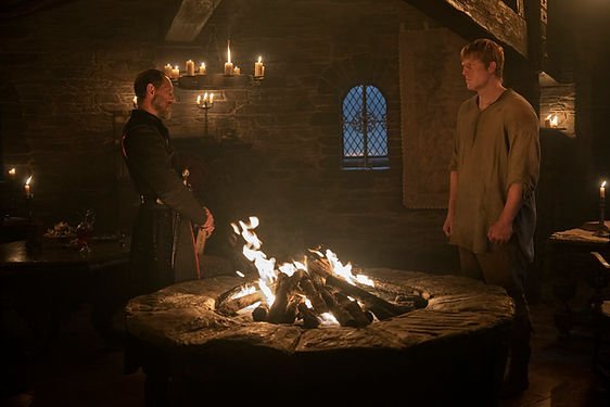Bertie Carvel as Baelor Targaryen and Peter Claffey as Ser Duncan the Tall stand across from each other with a fire pit between them in 'A Knight of the Seven Kingdoms'