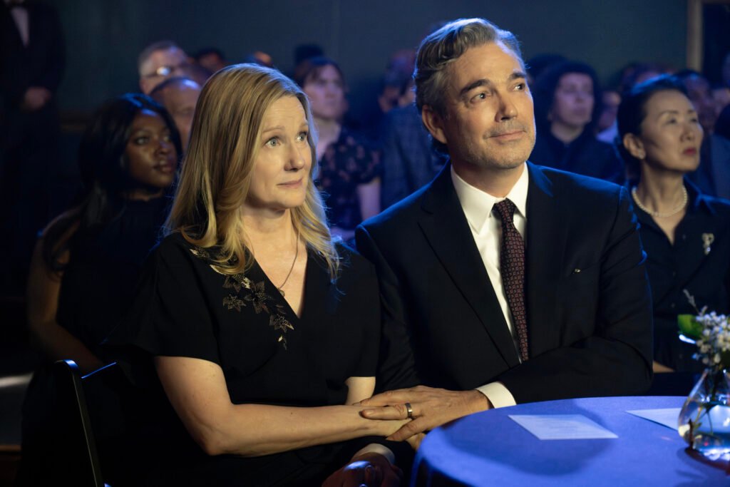 Laura Linney as Kristen Forrest-Bean and Jon Tenney as Jon Bean looking toward something, with their hands resting on top of each other, in American Classic