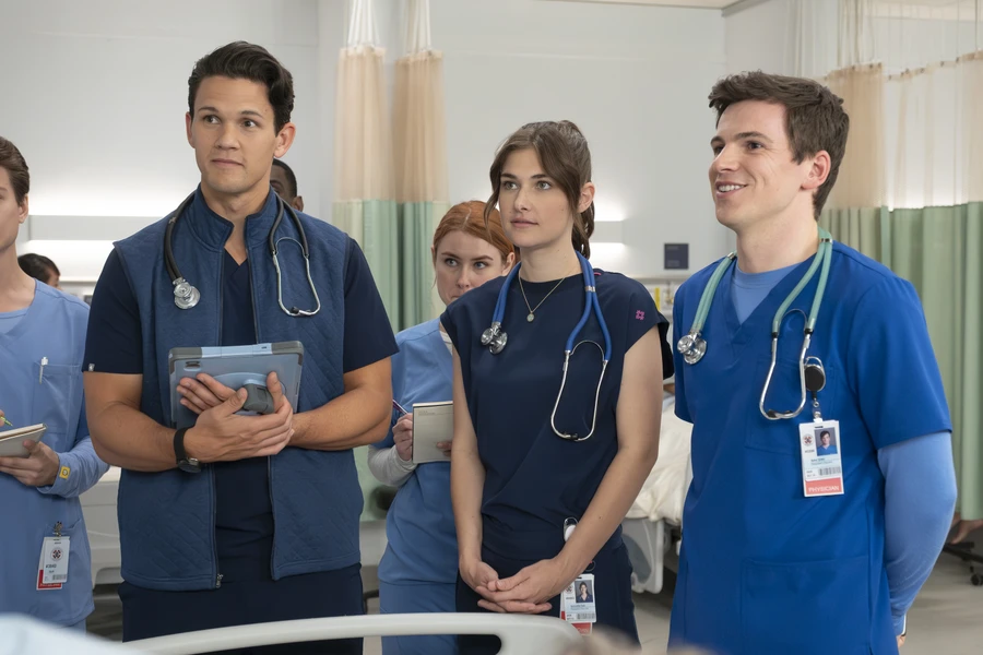 David Gridley as Blake, Ava Bunn as Tosh, and Jacob Dudman as Asher wearing medical scrubs and stethoscopes in Scrubs season 10 