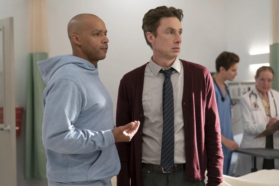 Donald Faison as Turk and Zach Braff as JD stand together in Sacred Heart hospital in Scrubs season 10