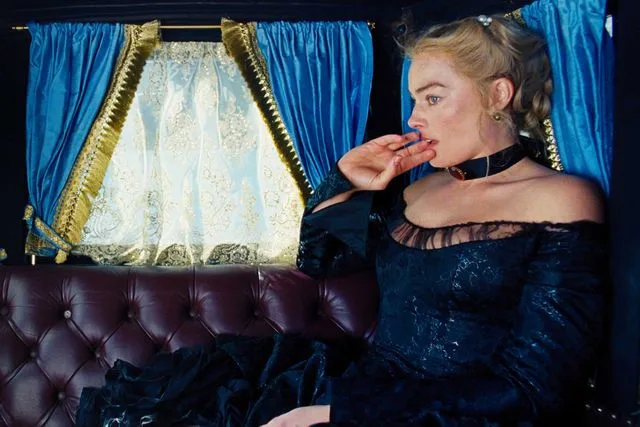 Margot Robbie as Catherine riding in a lavish carriage in Wuthering Heights