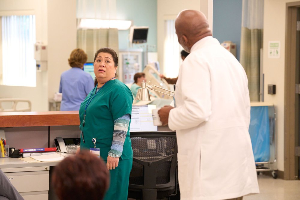 Kaliko Kauahi as Val and David Alan Grier as Ron stood talking to each other in St. Denis Medical 